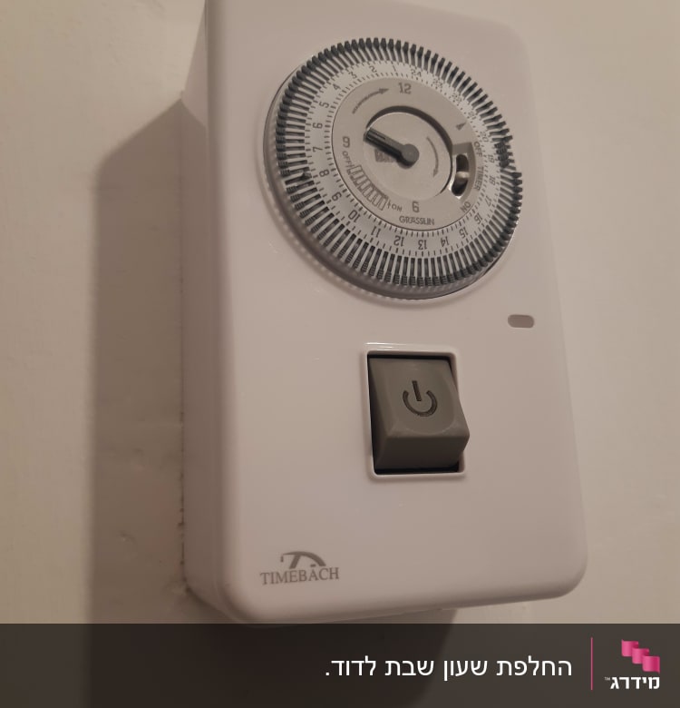 טיימר חשמלי עם כפתור הפעלה על קיר